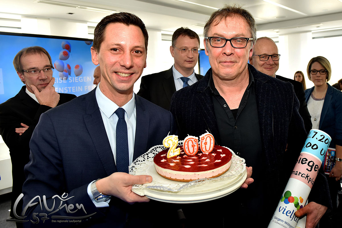 Firmenlauf- und Schülerlauf-Organisator Martin Hoffmann (rechts) überreichte Landrat Andreas Müller eine kleine Geburtstagstorte zur Feier "200 Jahre Kreise Siegen und Wittgenstein".